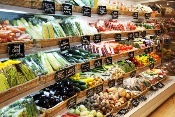 fresh mixed vegetables in a basket, tomatoes, cucumbers, peppers, grocery store